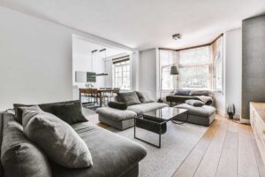 A living room with neutral decor, natural light, and clean, uncluttered furnishings prepared for a home showing.