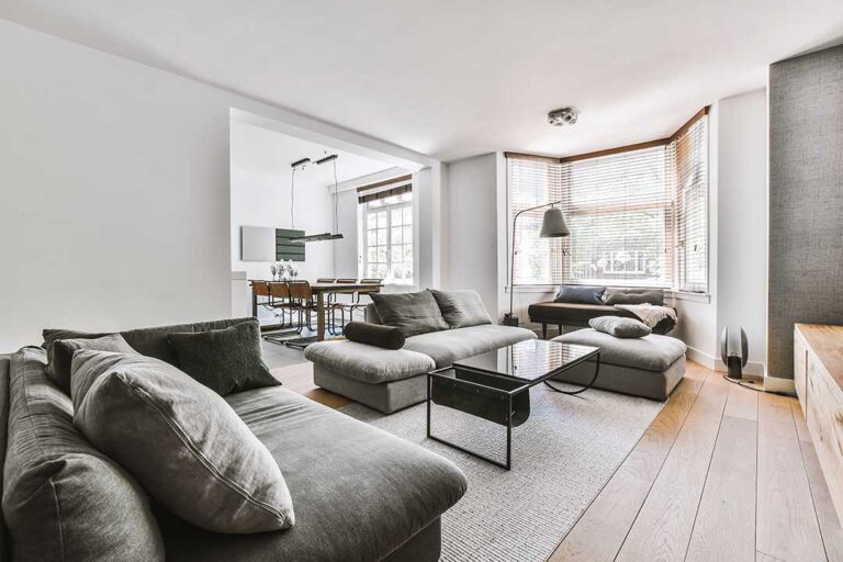 A living room with neutral decor, natural light, and clean, uncluttered furnishings prepared for a home showing.
