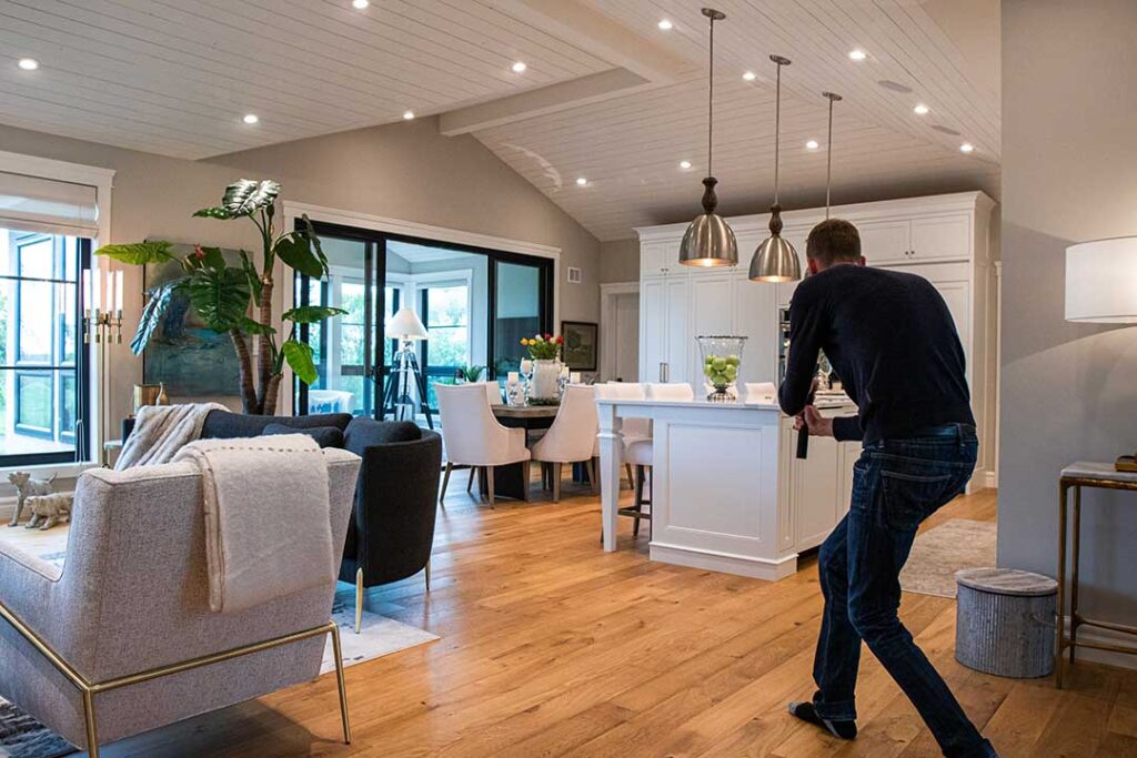 Buyers review a home offer and inspection notes at a kitchen table with a calculator and paperwork.